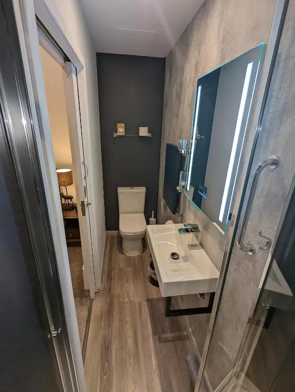 a bathroom with a sink and a toilet and a mirror at Cambeth Lodge Guesthouse in Inverness
