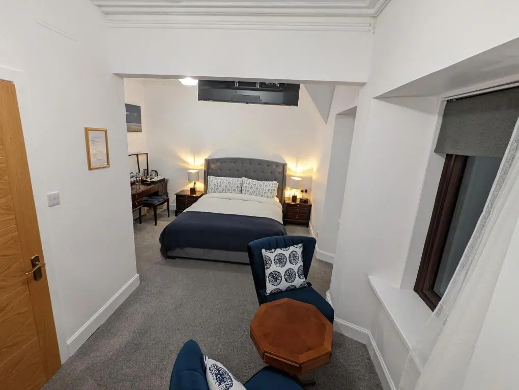 a small bedroom with a bed and a chair at Cambeth Lodge Guesthouse in Inverness