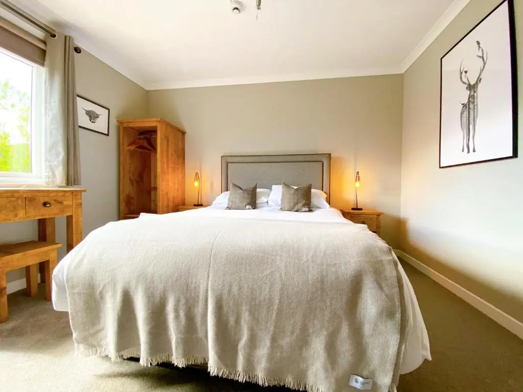 a bedroom with a large white bed with two pillows at Cairngorm Guest House in Aviemore