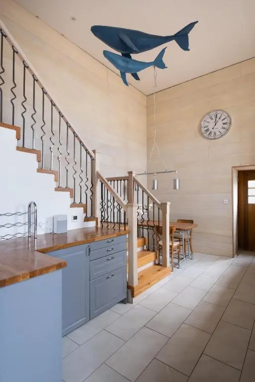 a kitchen with stairs and a clock on the wall at The Blue Hoose in Gardenstown
