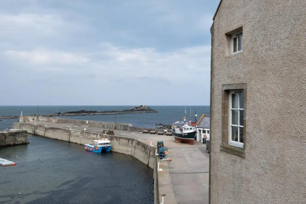 a view of a harbor with boats in the water at The Blue Hoose in Gardenstown