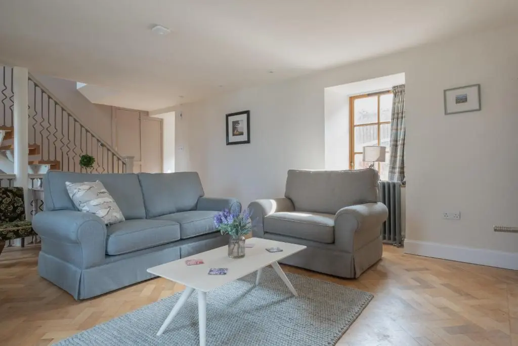 a living room with two couches and a table at The Blue Hoose in Gardenstown
