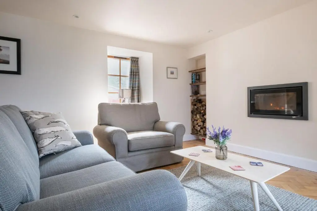 a living room with a couch and a chair and a table at The Blue Hoose in Gardenstown