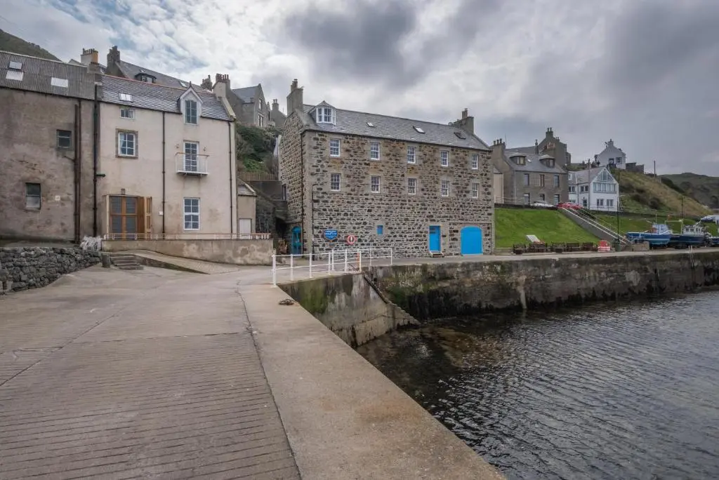 a group of buildings next to a body of water at The Blue Hoose in Gardenstown