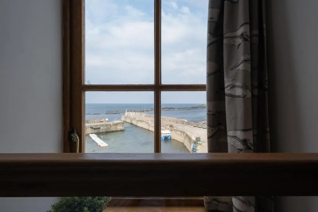 a window with a view of a harbor at The Blue Hoose in Gardenstown