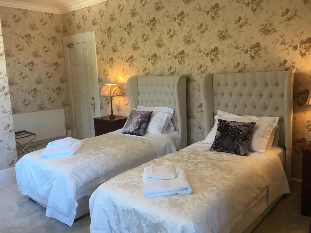 two beds sitting next to each other in a bedroom at Ledgowan Lodge Hotel in Achnasheen