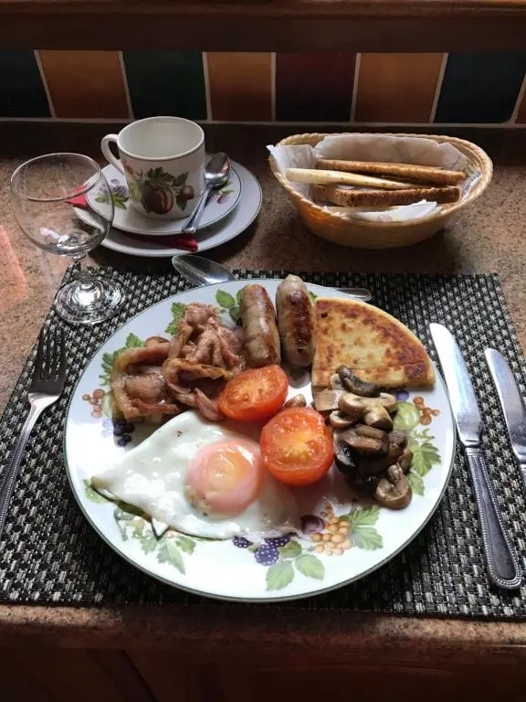a plate of food with eggs sausage and bread on a table at Inchrye Bed & Breakfast in Inverness