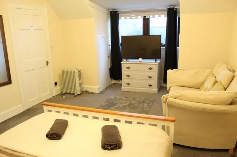 a living room with a couch and a tv at Beautiful house on NC500 Route in Wick