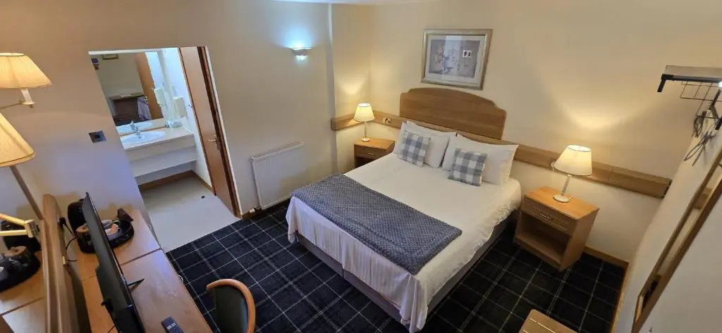 a small room with a bed and a mirror at The Red Lion Tavern in Fochabers