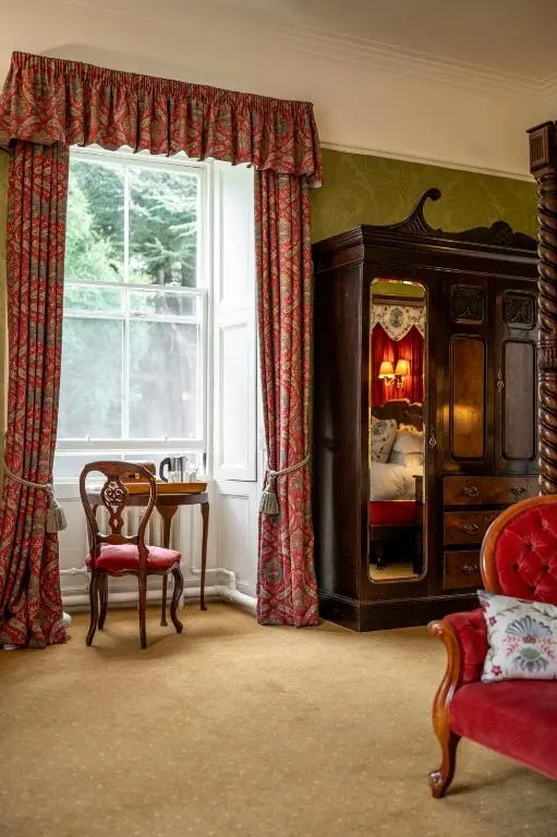 a bedroom with a bed with a fire in it at Bunchrew House Hotel in Inverness