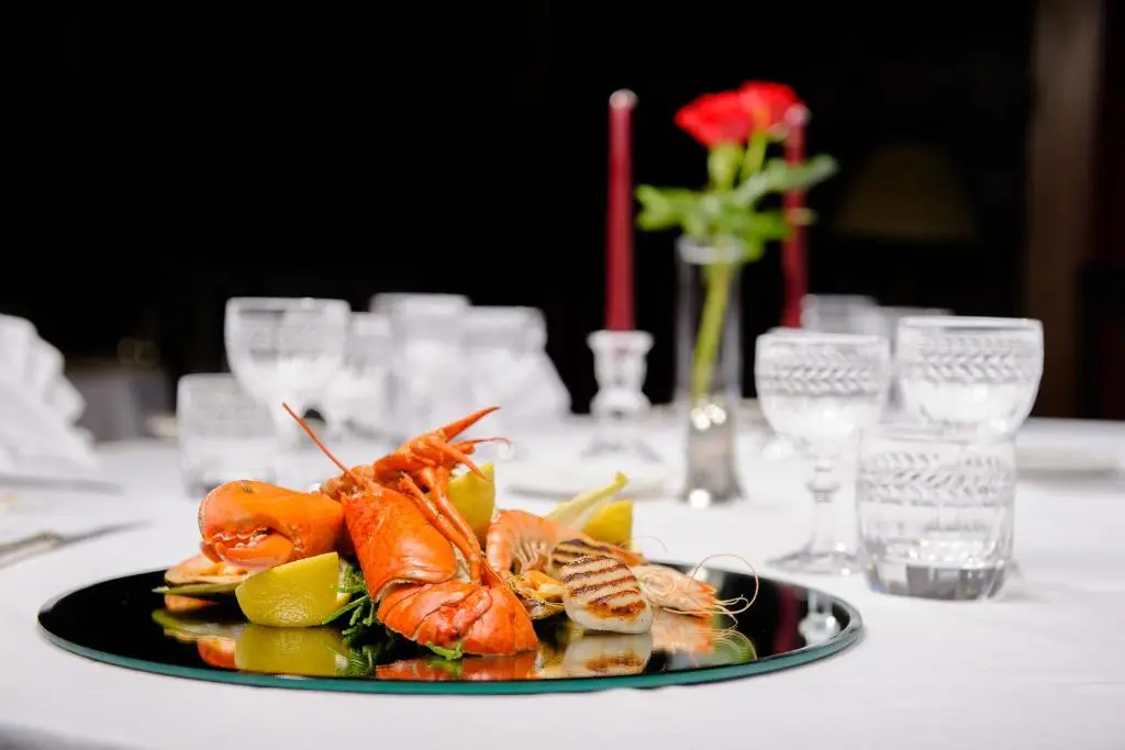 a plate of food with shrimp and vegetables on a table at Bunchrew House Hotel in Inverness