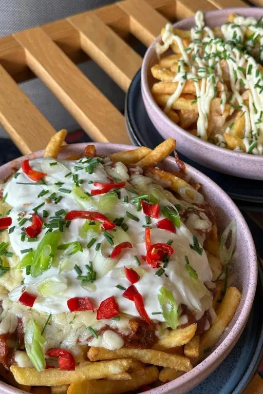 two bowls of food with french fries and onions at Aloft Aberdeen TECA in Aberdeen