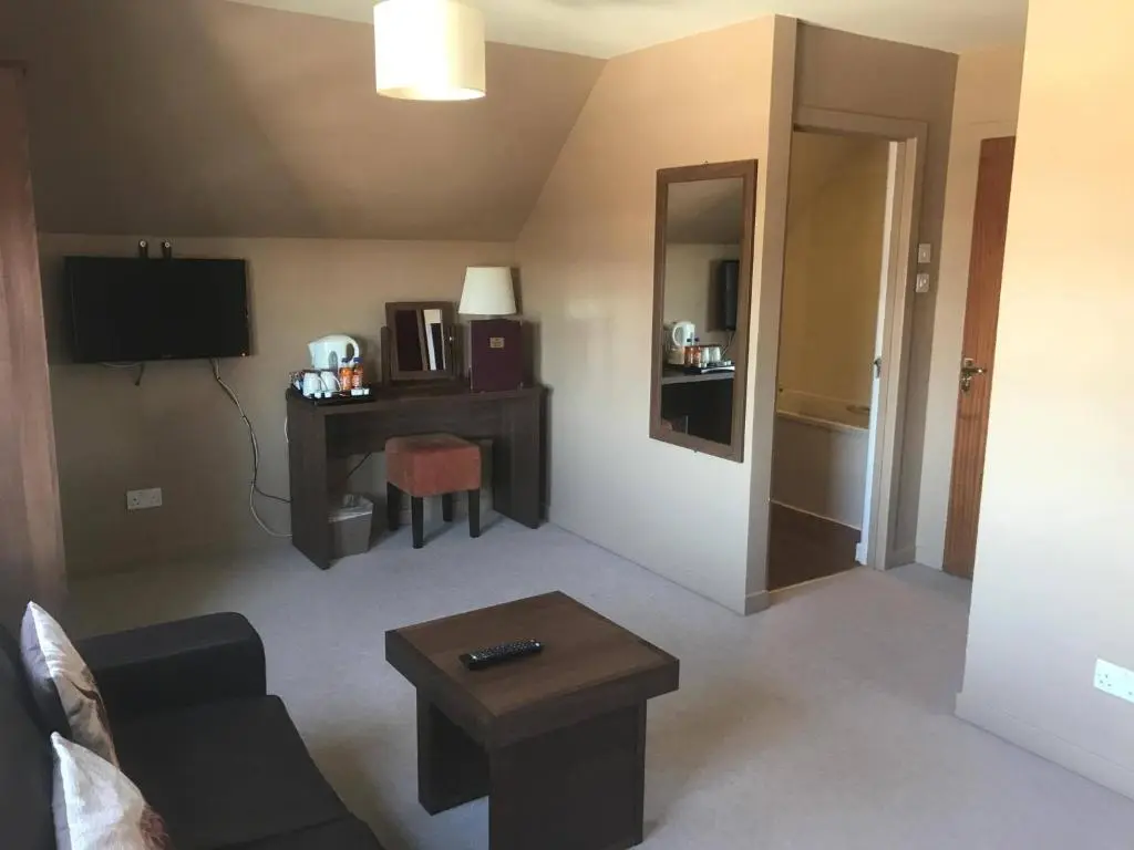 a living room with a couch and a table at Chieftain Hotel in Inverness