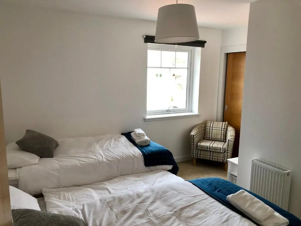 a living room with two beds and a window at Stelvio in Aviemore