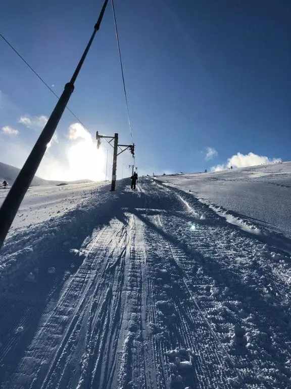 a person on a ski lift in the snow at Stelvio in Aviemore