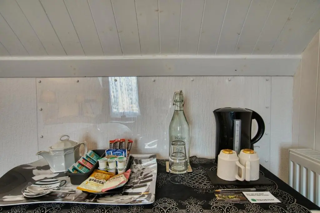 a counter top with a bottle and a coffee maker at Pitfaranne Guest House in Inverness