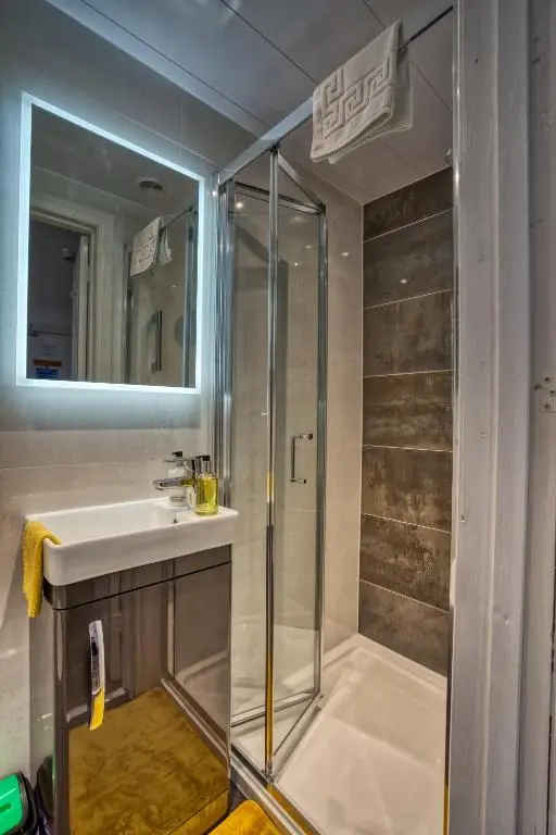 a bathroom with a shower and a sink at Pitfaranne Guest House in Inverness