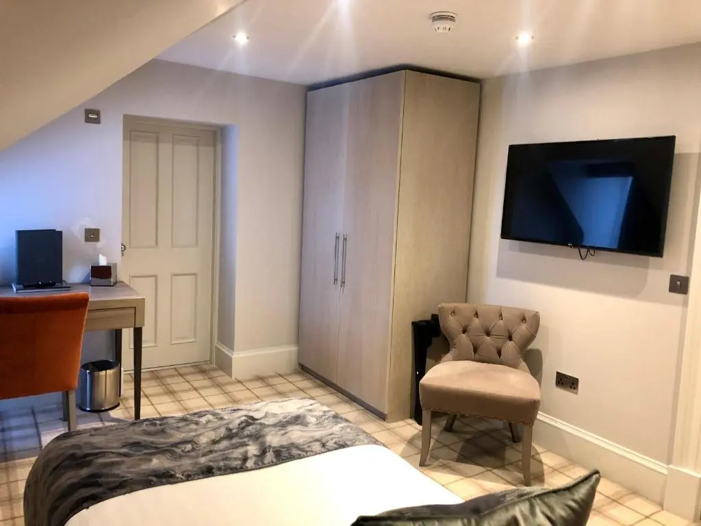 a bedroom with a bed and a desk and a television at The Seafield Arms-Cullen in Cullen