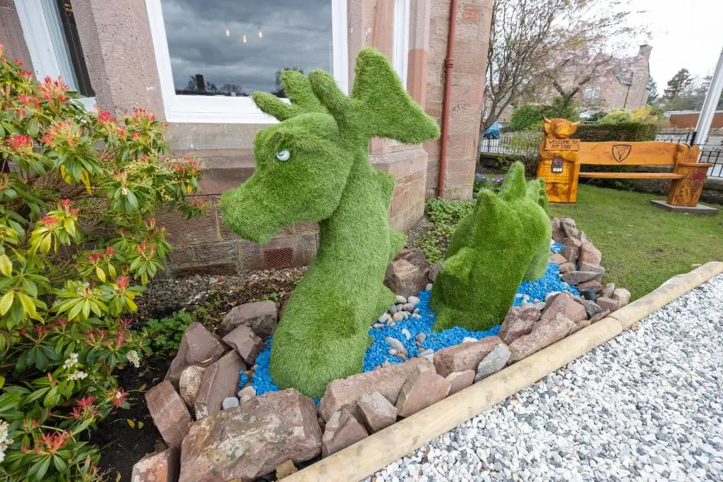a couple of green stuffed animals in a garden at Aye Stay in Inverness