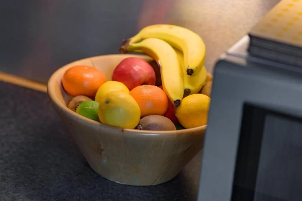 a wooden bowl of fruit next to a microwave at Ben Macdui in Banchory