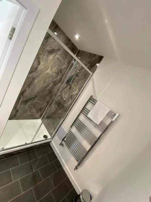 a walk in shower in a bathroom with a glass at The Station Hotel Insch in Insch