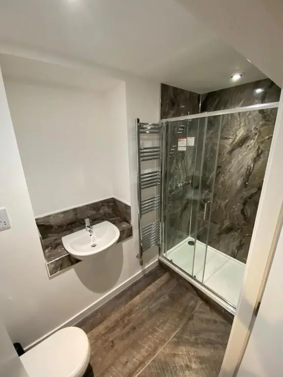 a bathroom with a shower and a toilet and a sink at The Station Hotel Insch in Insch