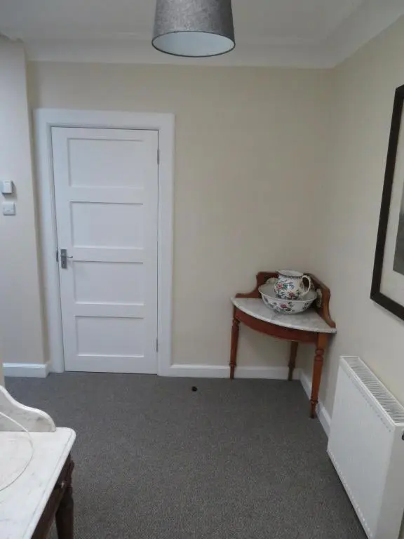 a room with a door and a table with a bowl on it at Balvraid Lodge B&B in Inverness