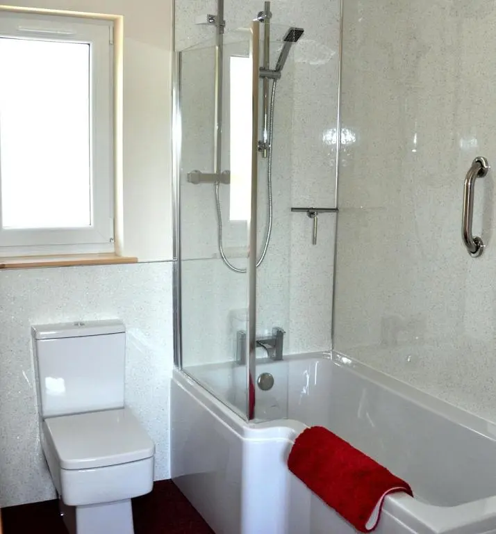 a bathroom with a tub and a toilet and a shower at Roe Deer Cottage in Beauly