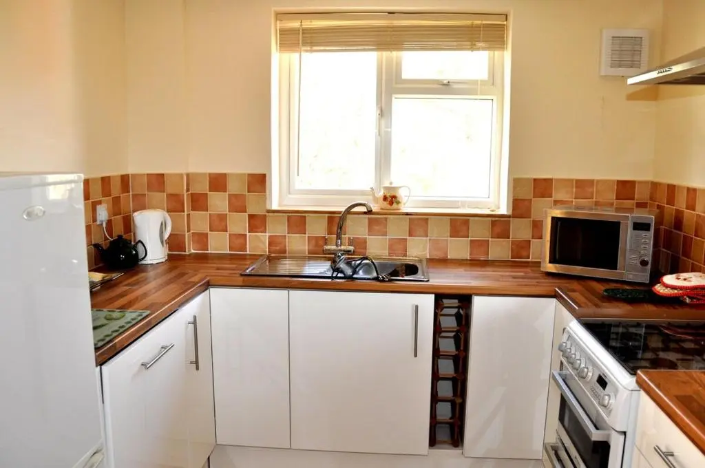 a kitchen with a sink and a microwave at Roe Deer Cottage in Beauly