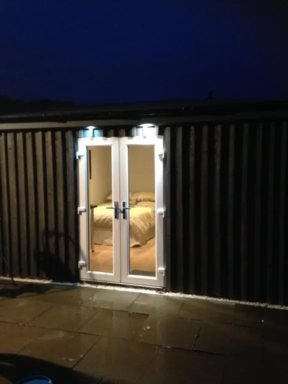 a door leading to a bedroom at night at ensuite garden room in Inverness