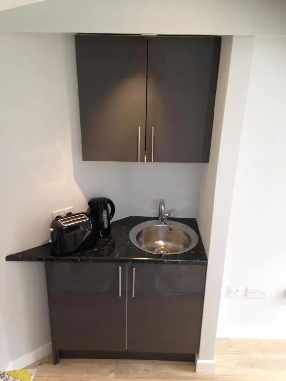 a bathroom counter with a sink and a mirror at ensuite garden room in Inverness