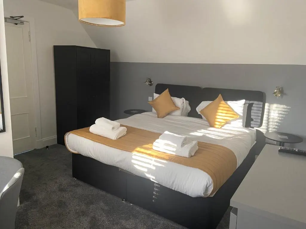 a bedroom with a large bed with white sheets and pillows at The Station Hotel in Alness