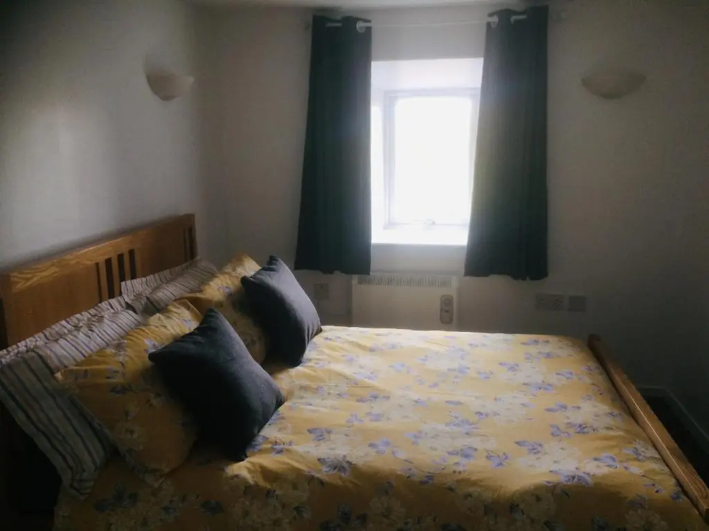 a bedroom with a bed with pillows and a window at Crossgates, Rosehearty in Rosehearty