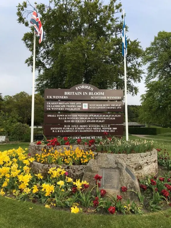 a park sign with flowers in front of it at Exclusive Private double room, en-suite wet room Private entrance in Forres