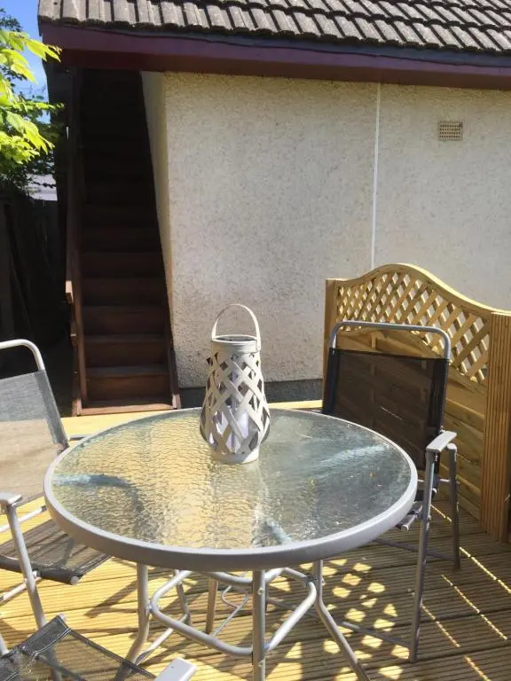 a vase sitting on a glass table on a patio at The Tree House in Inverness