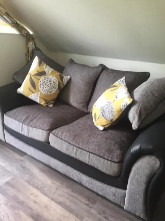 a couch with pillows on it in a room at The Tree House in Inverness