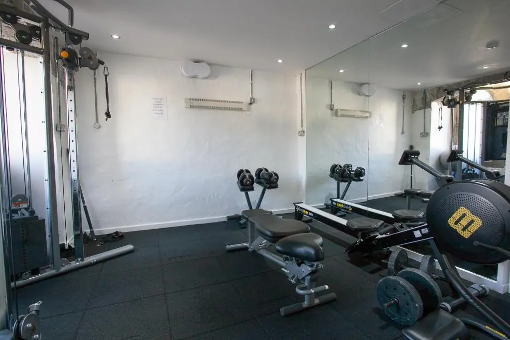 a room with a gym with weights and machines at Old School 10 Apartment With A View in Fort Augustus