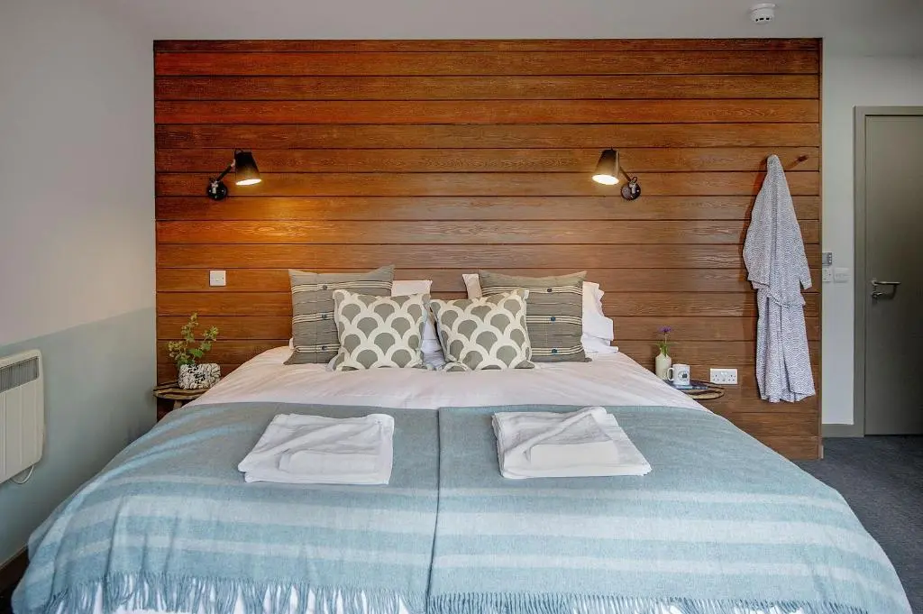 a bedroom with a large bed with a wooden headboard at Lock Chambers, Caledonian Canal Centre in Fort Augustus