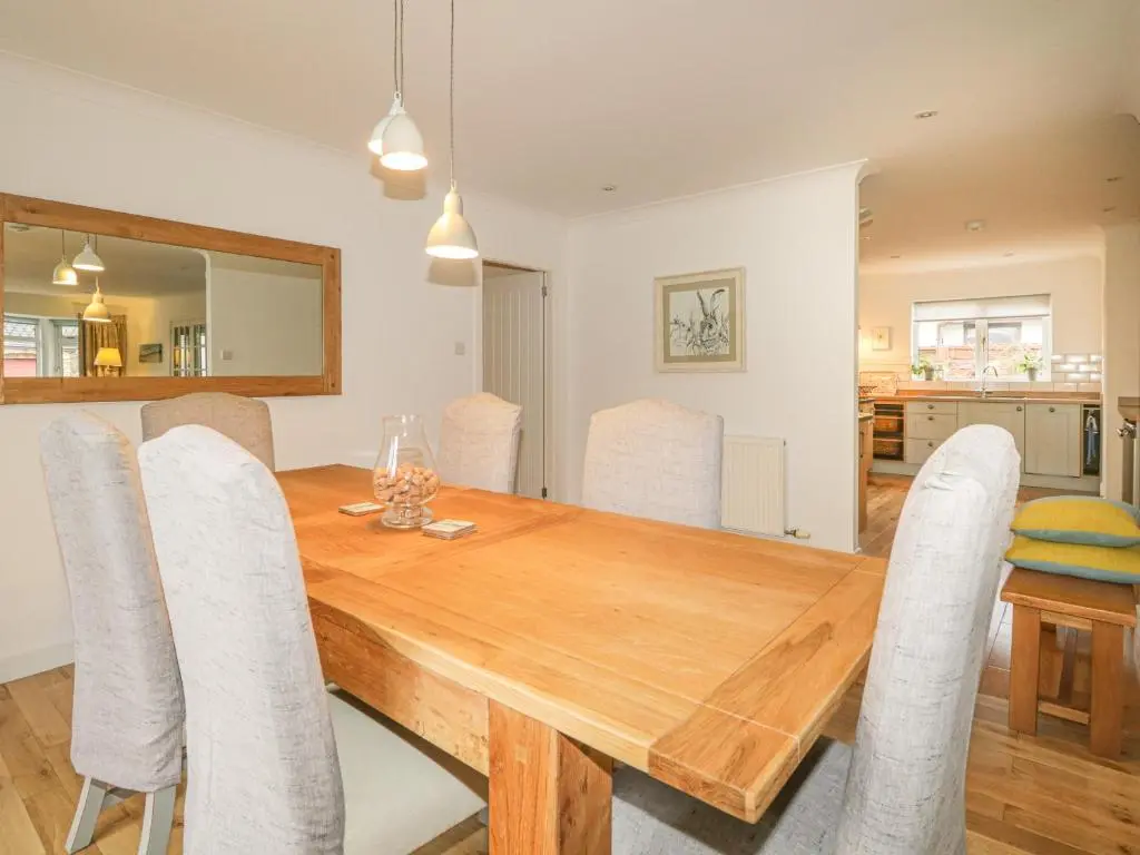 a dining room with a wooden table and chairs at Number 11 in Beauly