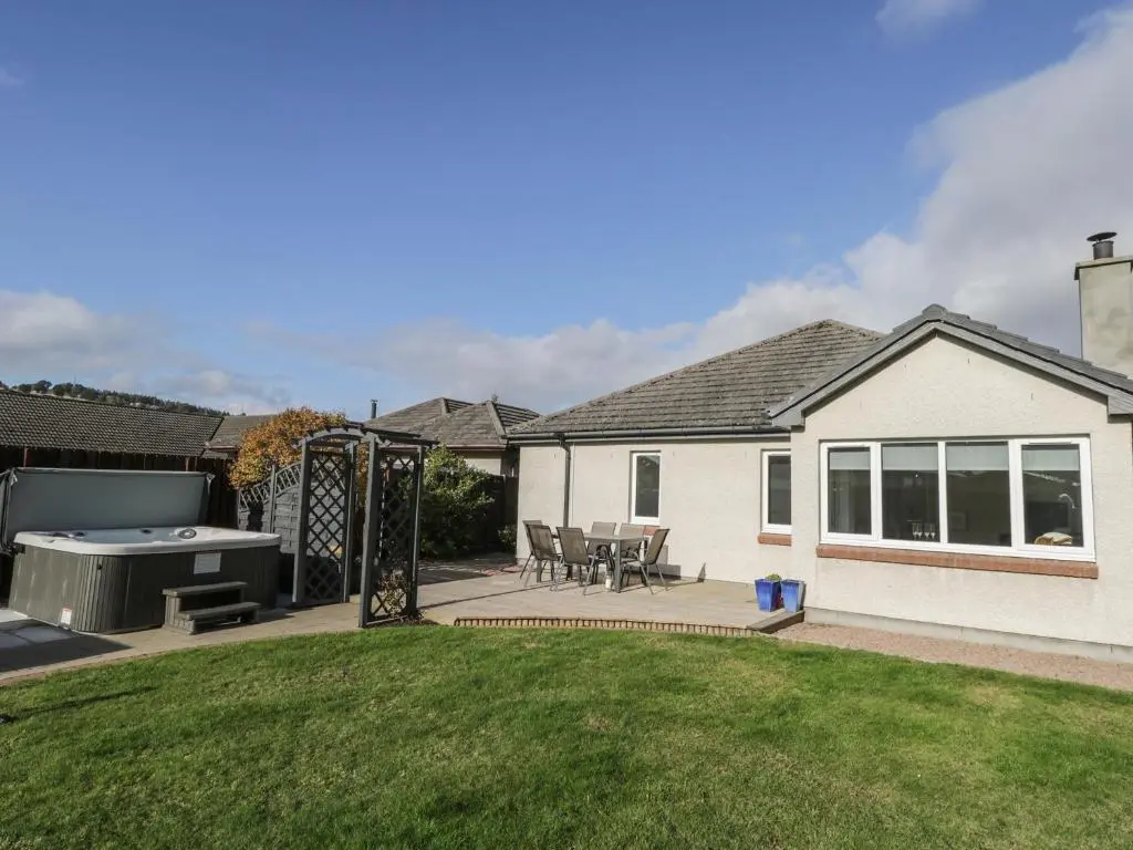 a backyard with a barbecue grill and a house at Number 11 in Beauly