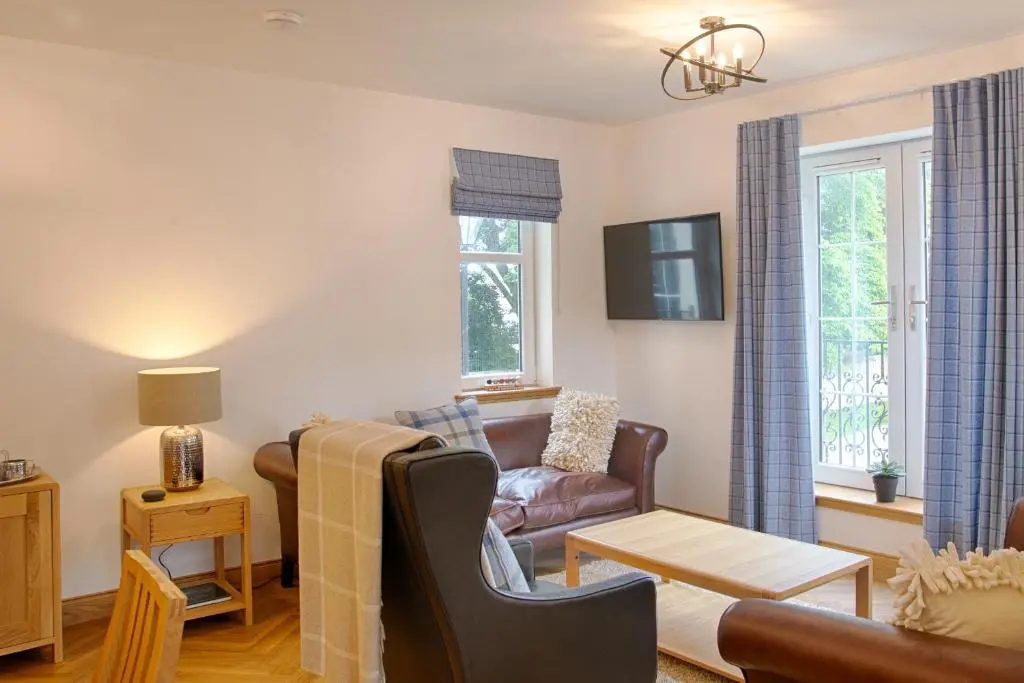 a living room with a couch and a table at Royal Golf Apartments in Dornoch