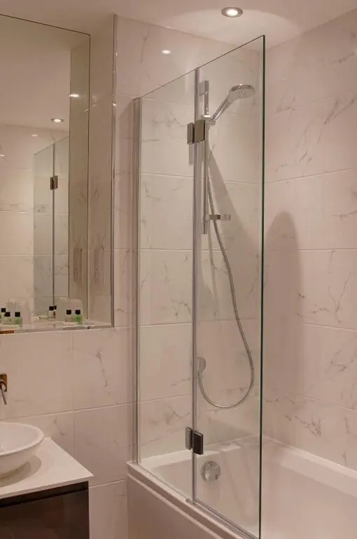 a shower with a glass door in a bathroom at Royal Golf Apartments in Dornoch
