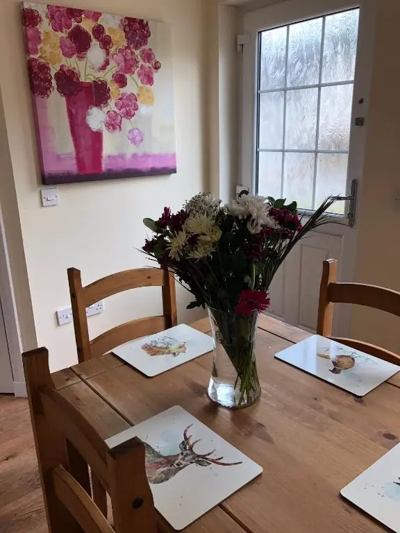 a vase of flowers sitting on top of a wooden table at 41 Larchwood Drive Holiday Home in Inverness