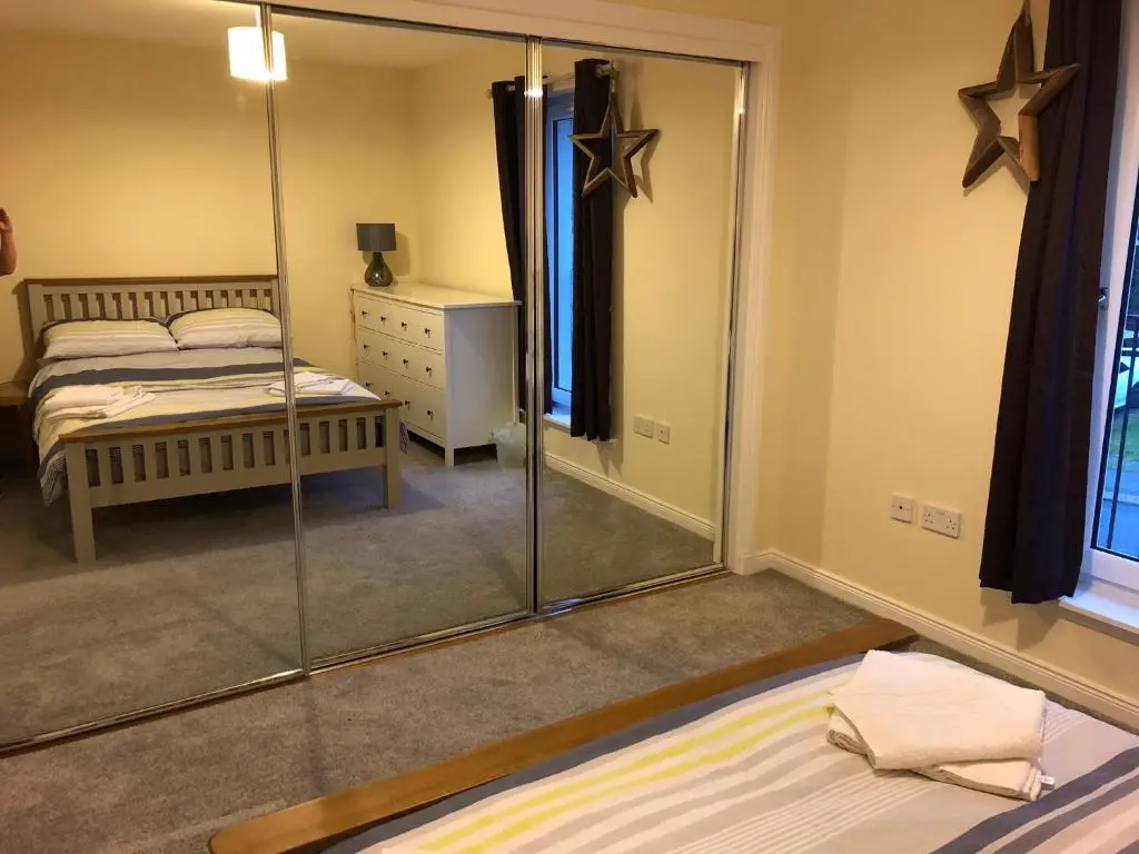 a bedroom with a mirror and a bed in it at 41 Larchwood Drive Holiday Home in Inverness