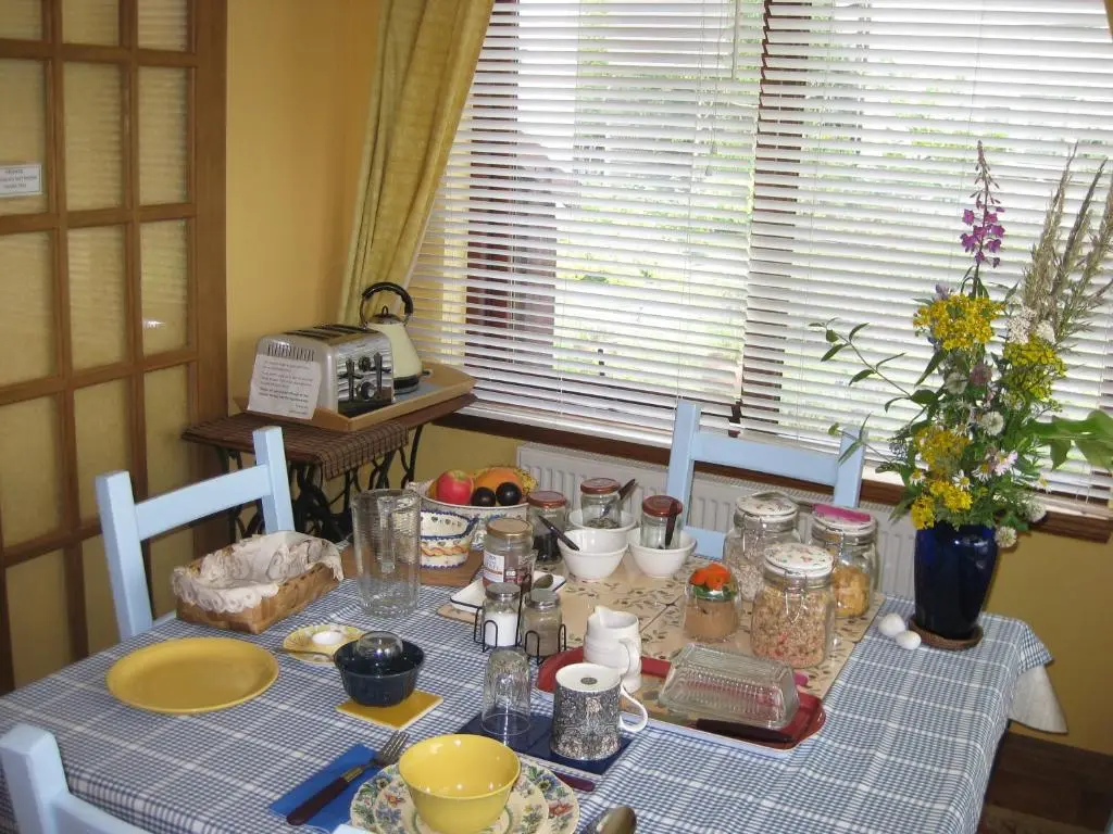 a dining room table with a blue and white table cloth at Sunflower Bed & Breakfast in Findhorn