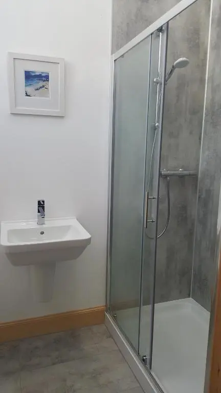 a bathroom with a shower and a sink at Helmsdale Lodge Hostel - all rooms en-suite in Helmsdale