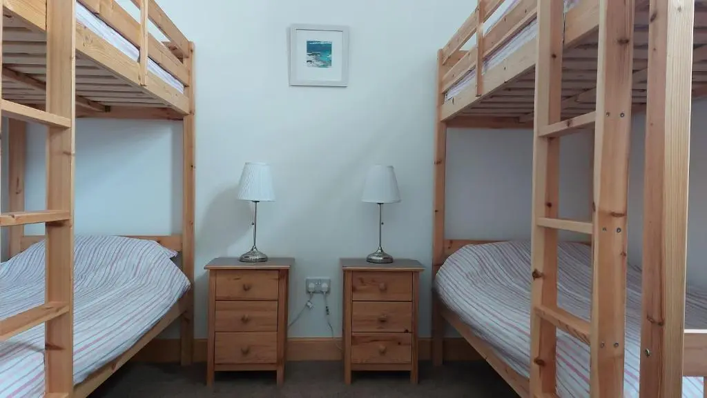 a bedroom with two bunk beds and two lamps at Helmsdale Lodge Hostel - all rooms en-suite in Helmsdale