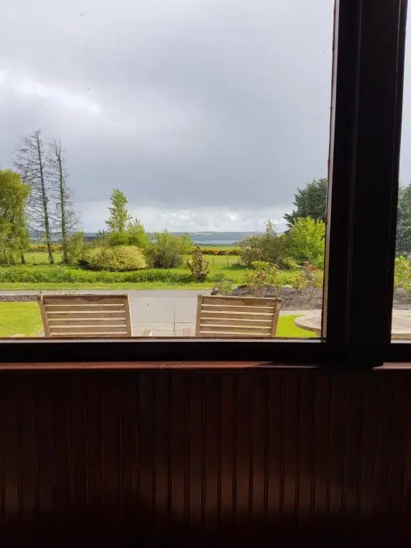 a view from a window of two benches at Delny Muir House in Invergordon