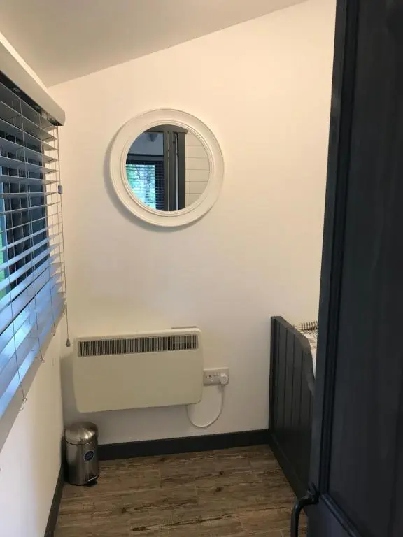 a bathroom with a mirror and a radiator at Star Cabin Lairg in Lairg