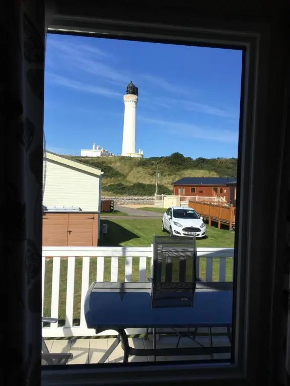 a view of a lighthouse from a window at 87 Lighthouse View Lodge in Lossiemouth